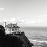 Mobile phone wallpaper of house on a cliff.